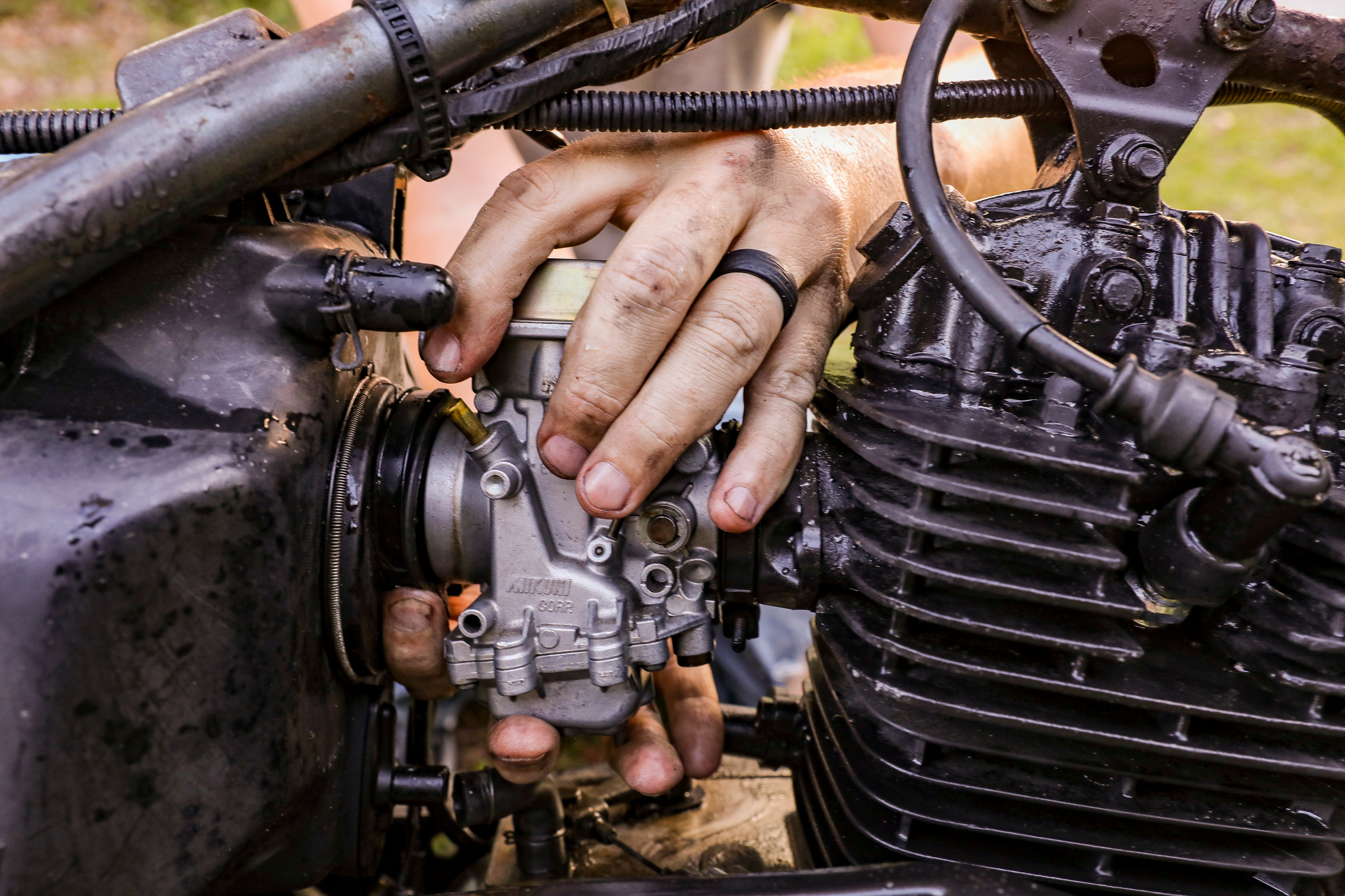 Close-Up Shot of a Person Fixing an Engine of a Motorcycle